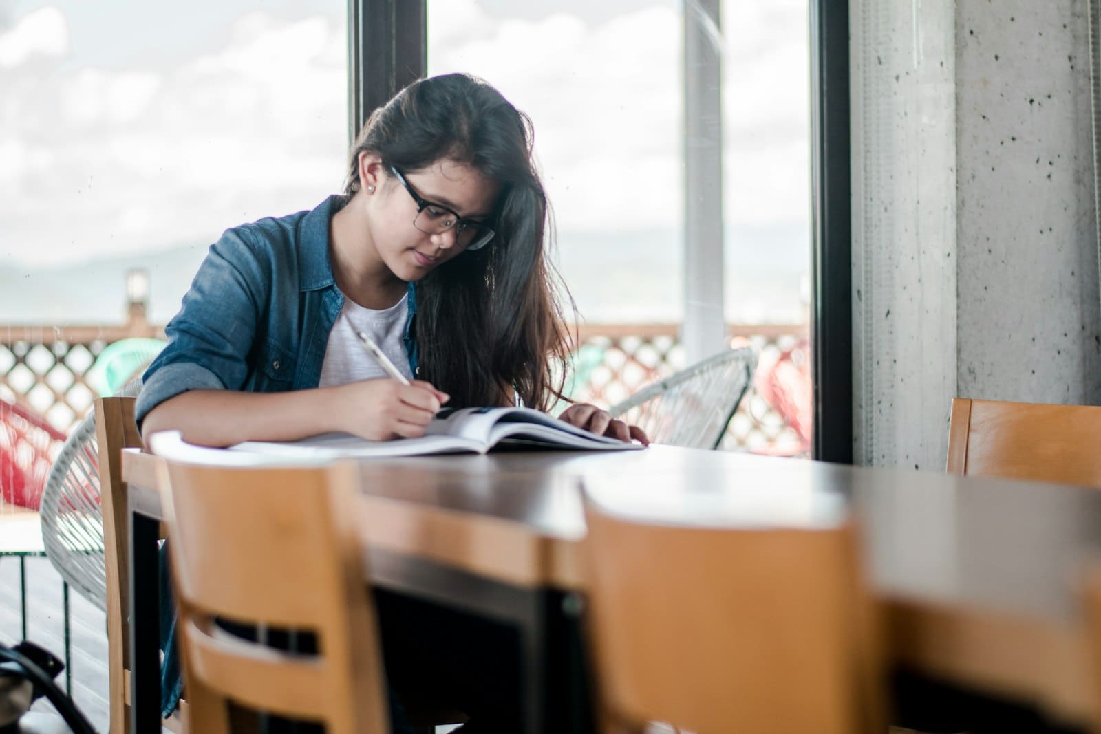 An adult studying and writing at a desk, preparing for GCSE Maths or Functional Skills